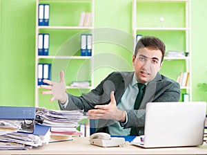 Businessman angry with excessive work sitting in the office