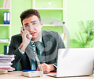 Businessman angry with excessive work sitting in the office