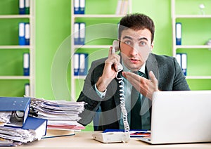 Businessman angry with excessive work sitting in the office