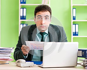 Businessman angry with excessive work sitting in the office