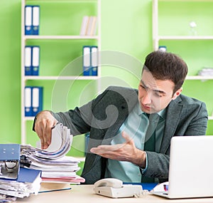 Businessman angry with excessive work sitting in the office