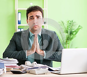 Businessman angry with excessive work sitting in the office