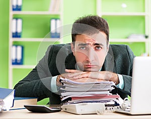Businessman angry with excessive work sitting in the office