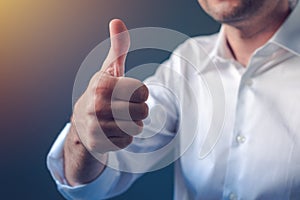 Businessman approving with raised thumb up gesture