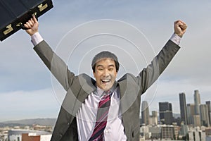 Businessman With Arms Out Against Buildings