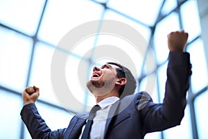 businessman with arms up celebrating his victory