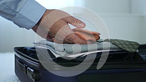 Businessman Arranges His Suitcase Preparing for a Business Trip