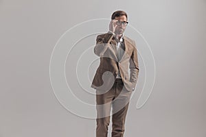 Businessman arranging his eyeglasses and holding one hand in pocket