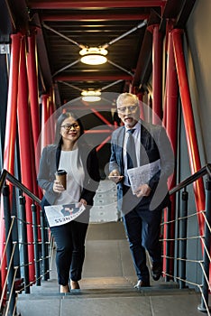 Businessman and asian businesswoman with newspapers