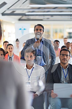 Businessman asking question during seminar