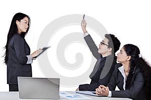 Businessman asking to the meeting leader
