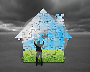 Businessman assembling house shape puzzles with nature image