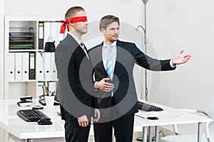 Businessman Assisting Blindfolded Partner