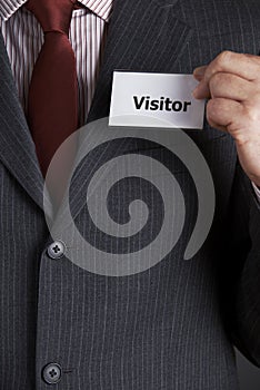 Businessman Attaching Visitor Badge To Jacket