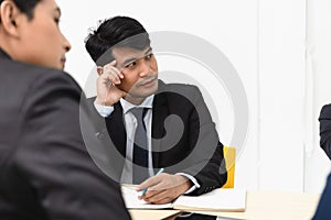 Businessman attend a meeting listening with intend bore and serious mood.Asian Business male boring at work in office seminar