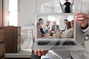 Businessman attending online video conference via modern laptop indoors, closeup