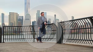 Businessman in autumn jacked waiting outdoor in New York. Mature man in suit outside in NYC. Businessman with laptop and