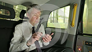 Businessman in the back of a taxi cab at night