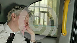 Businessman in the back of a taxi cab at night