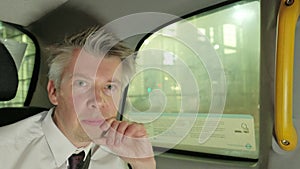 Businessman in the back of a taxi cab at night