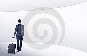 Businessman with suitcase walking in waiting room