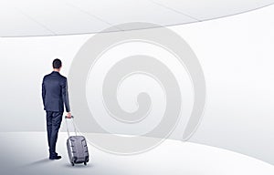 Businessman with suitcase walking in waiting room