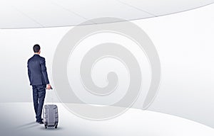 Businessman with suitcase walking in waiting room