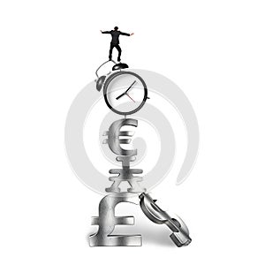 Businessman balancing on alarm clock and currency symbols