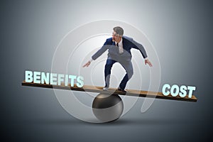 Businessman balancing between cost and benefit in business conce photo