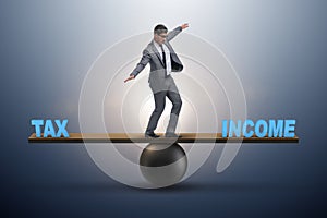 The businessman balancing between income and tax in business concept