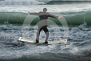 Businessman balancing on money boat floating in ocean with waves