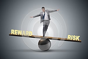 The businessman balancing between reward and risk business concept