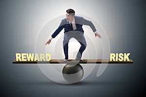 The businessman balancing between reward and risk business concept photo