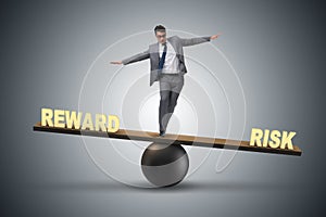 The businessman balancing between reward and risk business concept photo