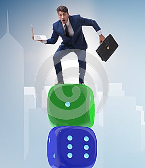 Businessman balancing on top of dice stack in uncertainty concep