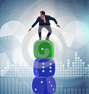 Businessman balancing on top of dice stack in uncertainty concep