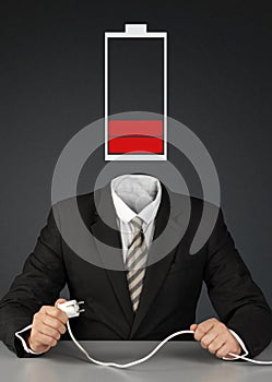Businessman with battery head and plug, charge you mind concept