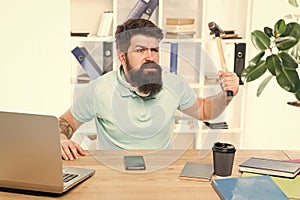 Businessman with beard and mustache gone mad with hammer in a hand. Angry aggressive businessman in office. Frustrated