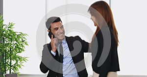 Businessman beckoning woman to come near him.