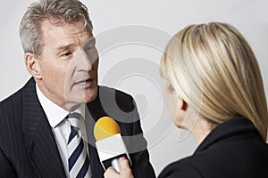 Businessman Being Interviewed By Female Journalist With Microphone