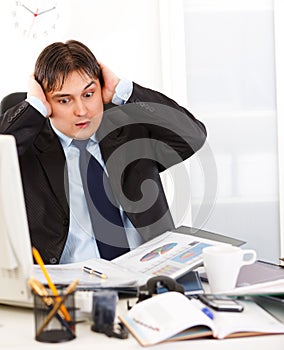 Businessman being overloaded with loads of work photo