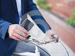 Businessman on a bicycle, phone close-up with his hands