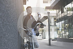 Businessman with bike using iPod on street.