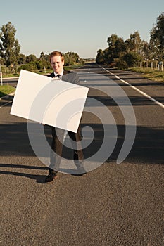 Businessman with billboard on road