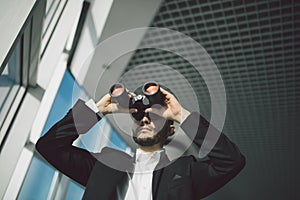 Businessman with binoculars spying