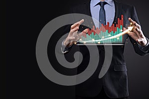 Businessman on a black background presses, presses a finger on a positive growth arrow. Graphs of indicators. Business development