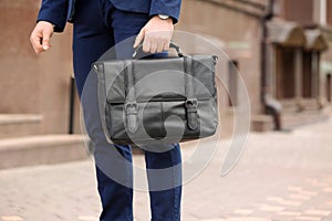 Businessman with black briefcase in hand outdoors