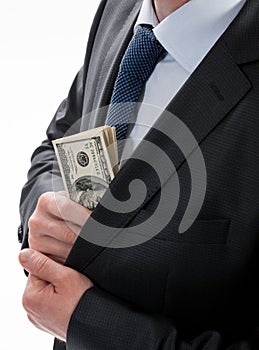 A businessman in a black suit putting money in his pocket