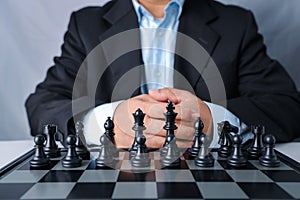 Businessman in black suit sitting and control team in front to success position on competition business game, meaning of success