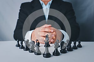 Businessman in black suit sitting and control team in front to success position on competition business game, meaning of success